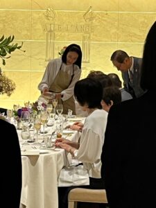 レストランの会食で、テーブルのグラスにティードリンクを注ぐ様子